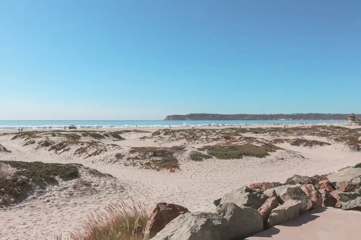Coronado Beach with wide white sand and gentle turquoise waves.